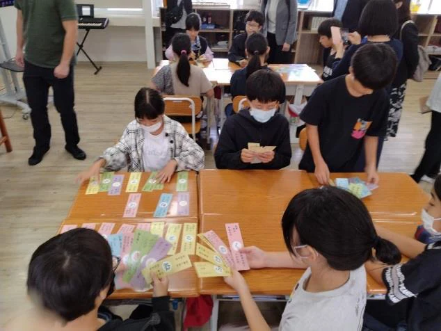 高雄日本人学校で、子どもたちが机の上のかるたに取り組む様子