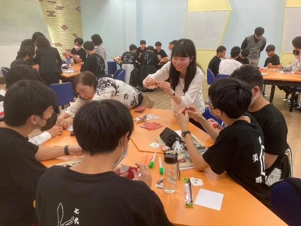 嘉義高校の教室で、日本と台湾の参加者が同じ机を囲み、折り紙に取り組む様子