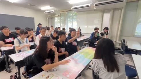 千葉大学の教室で、机上の教材を囲んで交流する参加者