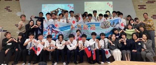 嘉義高校の教室で、横断幕を囲んで並ぶ日台の参加者