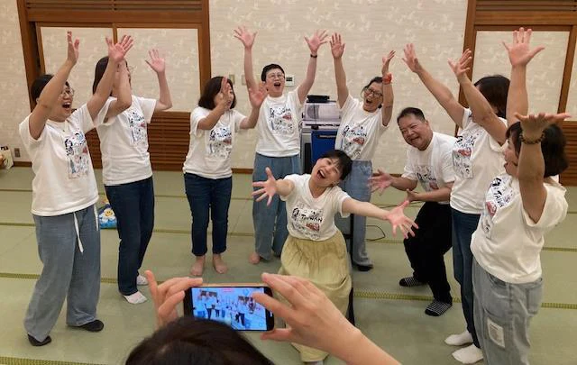 小豆島での交流会で、参加者が両手を上げて台湾クイズの優勝を祝う様子