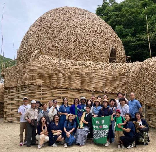 王文志氏の竹の作品「抱擁・小豆島」の前に集まる参加者