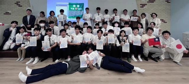 嘉義高校の教室で、書道作品を持って並ぶ参加者