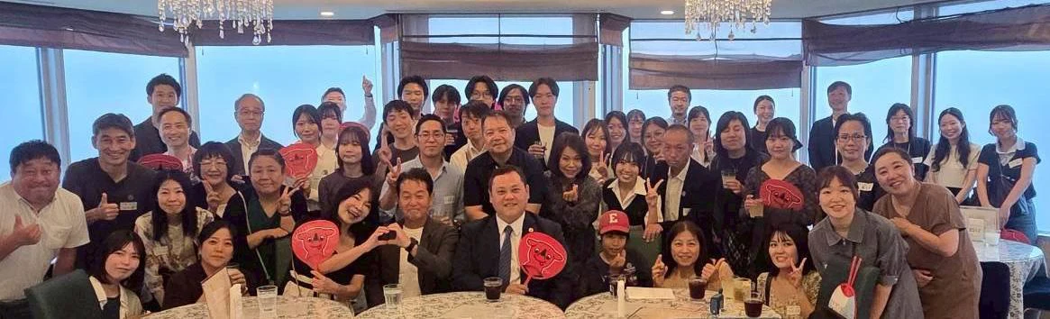 幕張での歓迎懇親会で、うちわを持ち一緒に並ぶ参加者